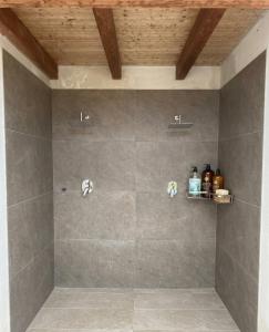 a bathroom with a shower with gray tiles at Le tenute di punta bianca in Agrigento +18 photos