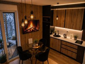 a kitchen with a table and a fireplace at Oaza in Bjelašnica