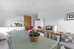 a kitchen with a table with a pot of flowers on it at Cottage in the middle of nowhere in Ölfus