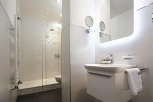 a white bathroom with a sink and a shower at Bielefelder Berghotel zum Stillen Frieden in Bielefeld