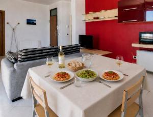 a table with plates of food and glasses of wine at Terrazza Sul Mare in Trapani