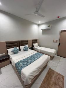 a bedroom with two beds with blue pillows at Hotel Prime Elite in Ahmedabad