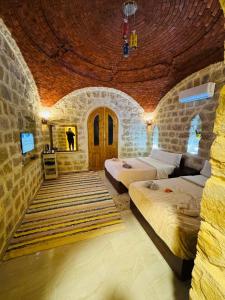 a bedroom with two beds and a stone wall at Pidgeon Lodge - Tunis Village in Tunis +169 photos