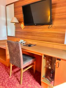 a room with a desk with a television on a wall at Hotel Wachau in Melk