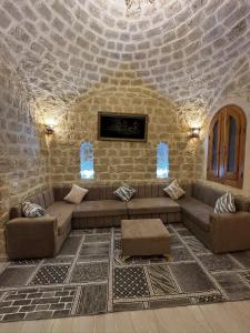 a living room with a couch and a stone wall at Pidgeon Lodge - Tunis Village in Tunis