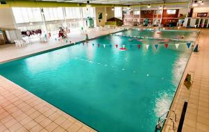a large swimming pool with many people in it at Bag End, Near Porth Beach, Garden & Stream in Newquay Bay Resort