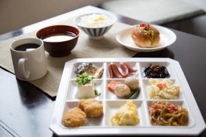 a table with a plate of food and a cup of coffee at Kyoto Plaza Hotel in Kyoto