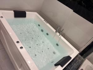 a bath tub filled with water in a bathroom at Hotel Prime Elite in Ahmedabad +31 photos