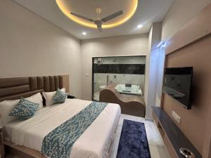 a bedroom with a large bed with a ceiling fan at Hotel Prime Elite in Ahmedabad
