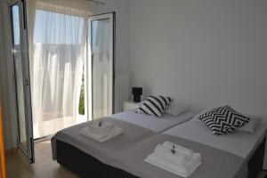 a bedroom with two beds and a large window at Black and White Spacious Apartment in Hvar