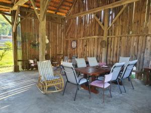 a wooden table and chairs in a barn at HH Klara in Ozalj