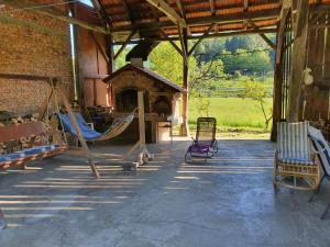 a porch of a house with a hammock and a fireplace at HH Klara in Ozalj
