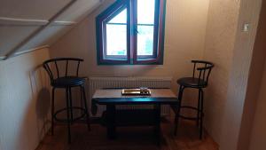 a table and two chairs in a room with a window at Apartman Bogatić 2 in Bogatić +2 photos