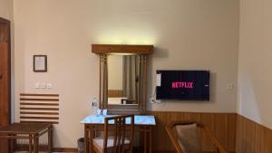 a room with a television and a table and chairs at Rock City Resort in Mingāora