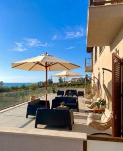 a patio with chairs and umbrellas on a building at Le tenute di punta bianca in Agrigento