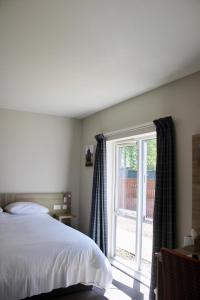 a bedroom with a bed and a large window at Riverstone Lodge Hotel in Perth