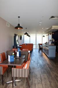 a restaurant with tables and chairs and a counter at Riverstone Lodge Hotel in Perth