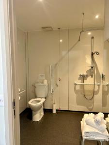 a bathroom with a toilet and a shower in it at Riverstone Lodge Hotel in Perth +12 photos
