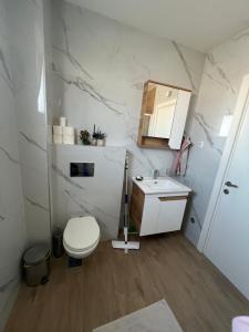 a white bathroom with a toilet and a sink at SunnyBar in Bar