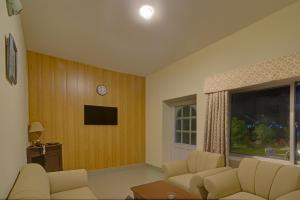 a living room with a couch and a tv and a window at Parhena Cottages Bella Naran in Naran