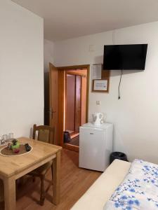 a small room with a table and a small refrigerator at Guest House Štefanija in Poljanak