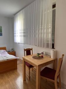 a room with a table and chairs and a bed at Guest House Štefanija in Poljanak