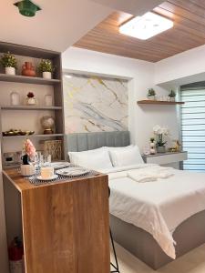 a bedroom with a bed and a desk in it at Nest & Rest Suites Azure North in San Fernando