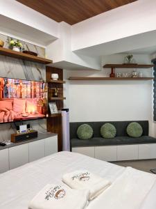 a room with a bed with two white towels at Nest & Rest Suites Azure North in San Fernando