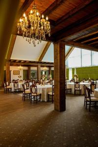 a dining room with tables and chairs and a chandelier at Casa Elena - Resort & SPA in Voronet