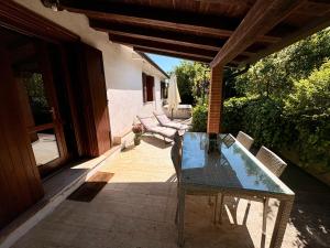 a patio with a glass table and chairs on a porch at Casetta La Pera in Perarolo