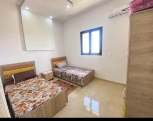 a bedroom with two beds and a window at villa amani in Al Maqārisah