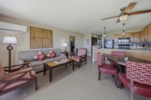 a living room with a couch and a table at Oceanfront Escape Pono Kai Resort A103 in Kapaa