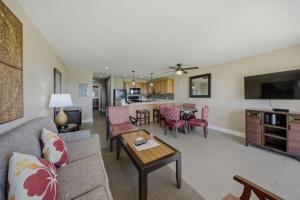a living room with a couch and a table at Oceanfront Escape Pono Kai Resort A103 in Kapaa