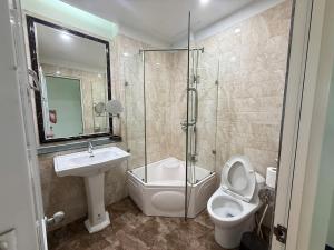 a bathroom with a toilet and a sink and a shower at Chiều Hotel in Ha Long