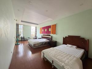a bedroom with two beds and a large window at Chiều Hotel in Ha Long