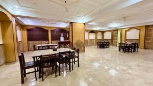 a dining room with tables and chairs in a building at Hotel New Sunder in Indore