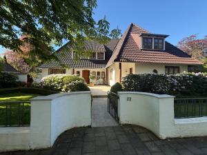a white house with a gate and a fence at Apartment am Bürgerpark in Bremerhaven