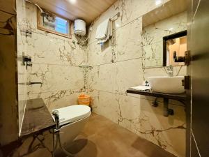 a bathroom with a toilet and a sink at Hotel New Sunder in Indore +29 photos