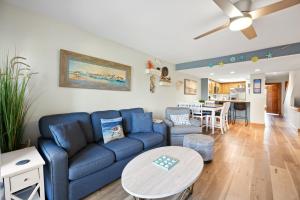 a living room with a blue couch and a table at QCB5 - Saltaire Sunrise in Nags Head +62 photos