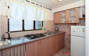 a kitchen with a stove and a sink and a window at Cozy Apartment In Jadranovo in Jadranovo +14 photos