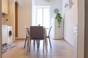 a kitchen with a table and chairs and a refrigerator at Casa Nel Blu in SantʼAlessio Siculo