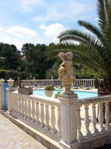 a statue on a white fence next to a pool at GITE LES PINS piscine chauffée jardin privatif climatisation Wifi parking in Peymeinade