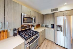 a kitchen with a stove and a refrigerator at Adobe Barona Dream in Palm Springs +27 photos