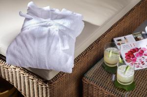 a towel and two drinks on a wicker table at Strandhotel Fontana in Timmendorfer Strand
