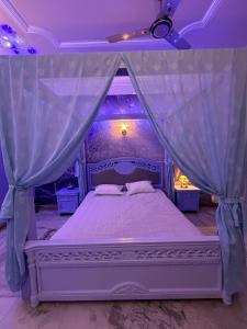 a bedroom with a canopy bed with a purple ceiling at H&R Homestay in Guwahati
