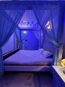 a bedroom with a canopy bed with blue lighting at H&R Homestay in Guwahati