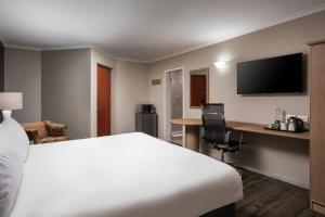 a hotel room with a bed and a desk at Protea Hotel by Marriott Cape Town Tyger Valley in Bellville