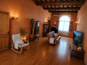 a living room with a couch and chairs and a tv at Locanda Corte Arcangeli in Ferrara
