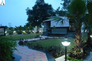 a house with a palm tree and a street light at Hotel Asha in Kannauj