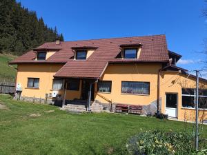 a yellow house with a red roof at Karacsony Guest House in Lunca de Sus